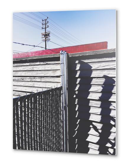steel fence and wooden fence with red building and blue sky background in the city Metal prints by Timmy333