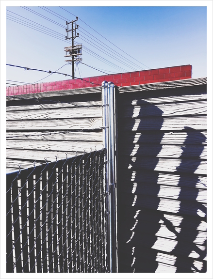 steel fence and wooden fence with red building and blue sky background in the city Art Print by Timmy333