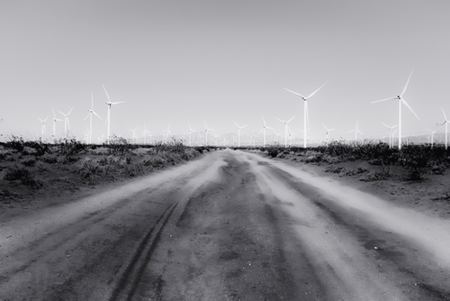 road in the desert with wind turbine in black and white Mural by Timmy333