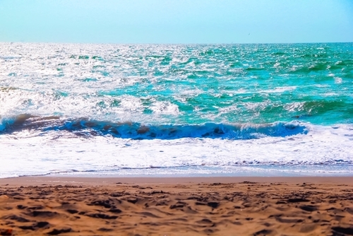 sandy beach with blue water and blue sky in summer Mural by Timmy333