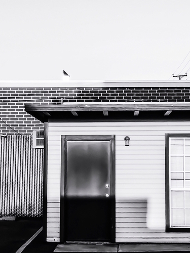 wood building with brick building background in black and white Mural by Timmy333